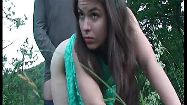 Teen in cute dress bent over in the grass