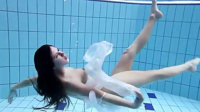 Leggy shaved girl swims in the pool