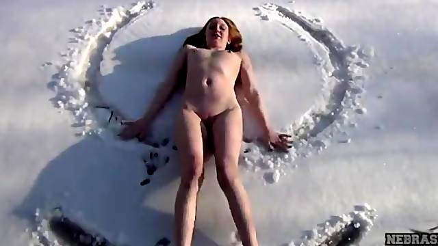 Redhead sits her naked ass in the snow
