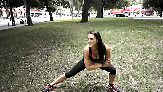 Sporty milf in skimpy workout clothes in a public park