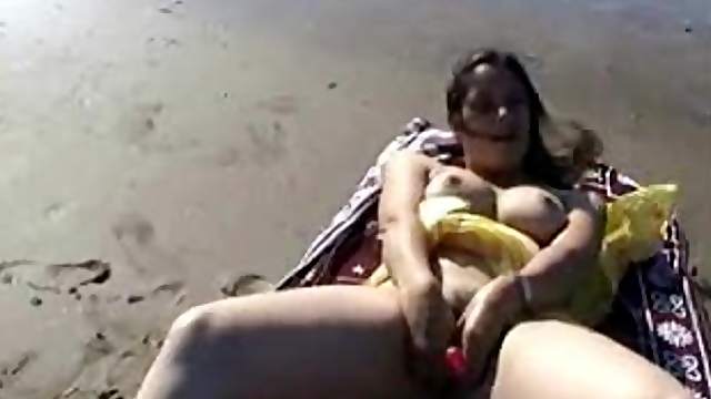Babe on the beach masturbating all alone